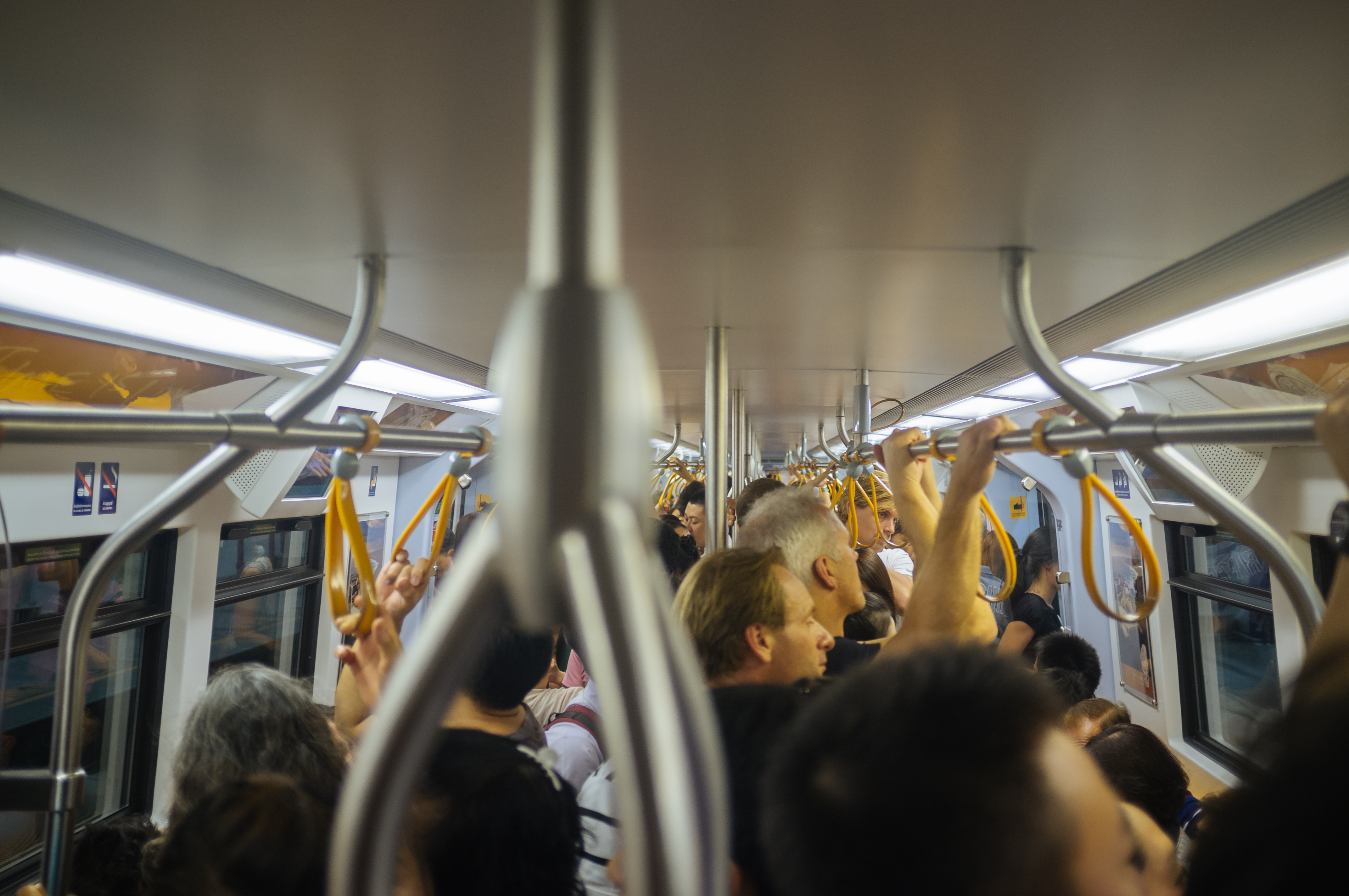 Innenraum eines BTS-Waggons in Bangkok mit sitzenden und stehenden Fahrgästen
