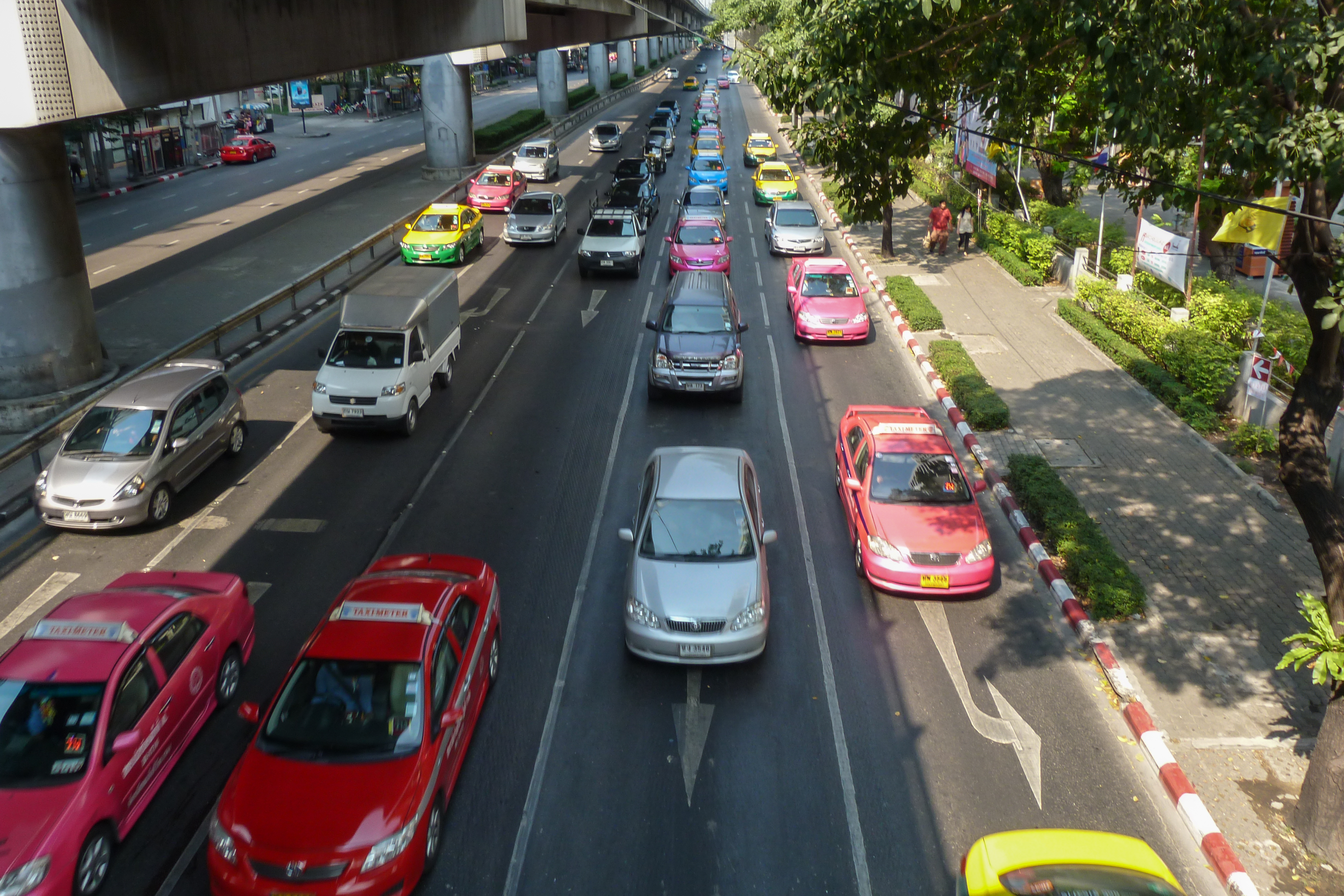 Bunte Metered Taxis auf einer Bangkok-Straße im Stadtverkehr