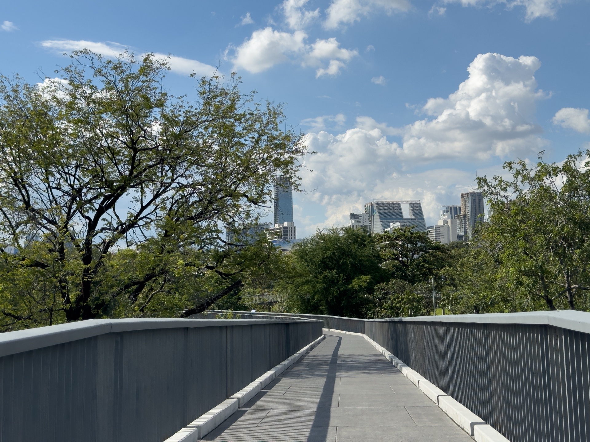 Brückenweg im Benjakity Park Bangkok mit Skyline im Hintergrund