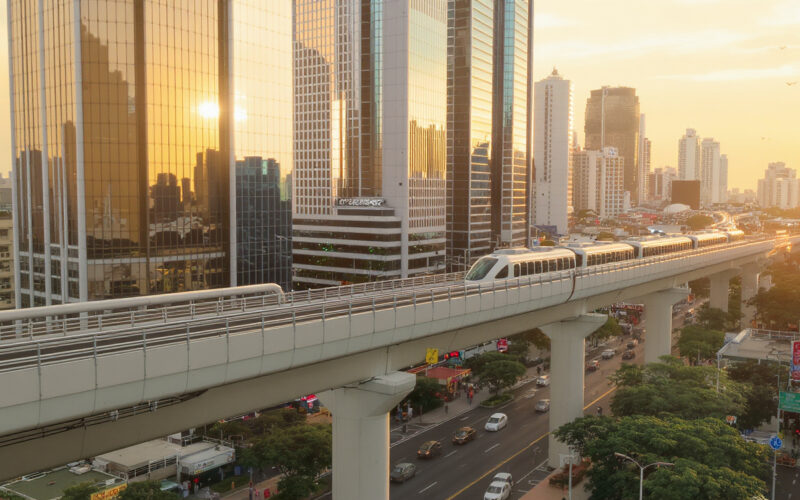 Silom Road Bangkok mit BTS Skytrain und Skyline bei Sonnenuntergang