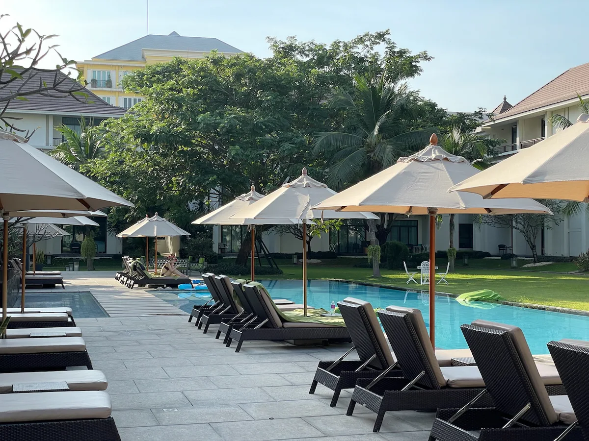 U Sathon Bangkok – Pool mit Liegestühlen und Sonnenschirmen
