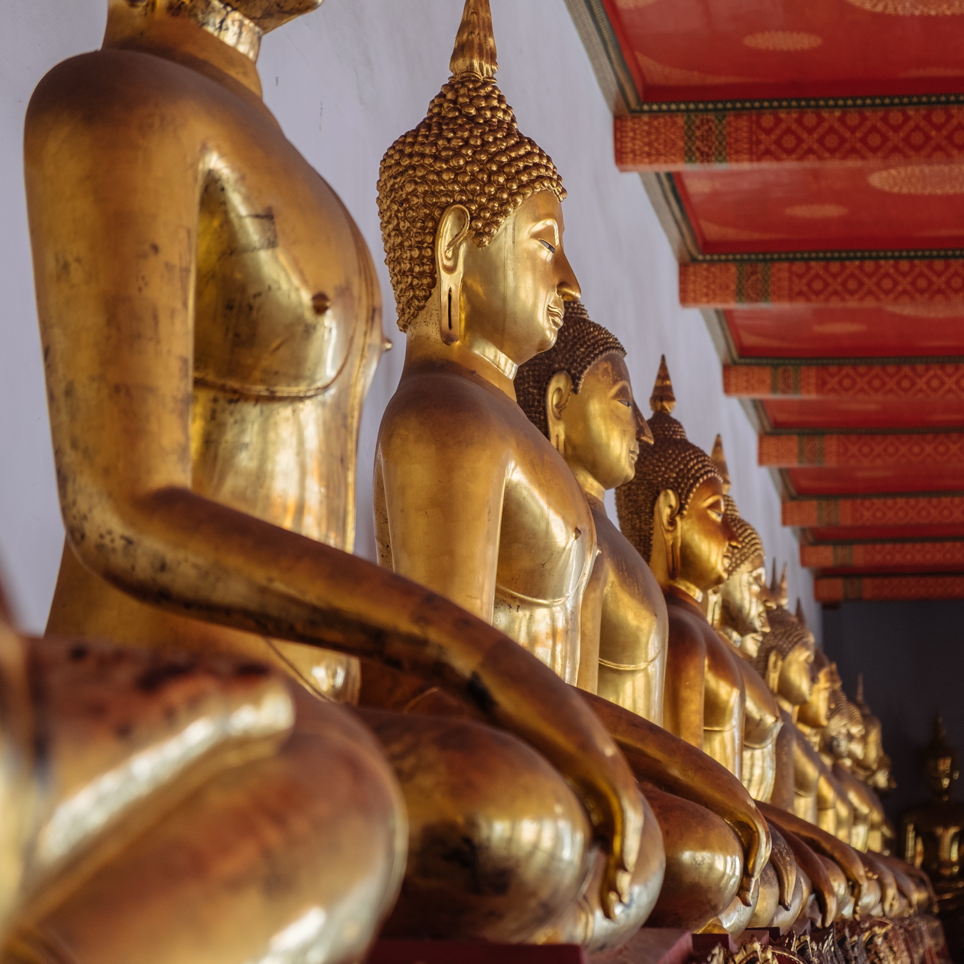 Reihe goldener sitzender Buddhas im Kreuzgang des Wat Pho Bangkok