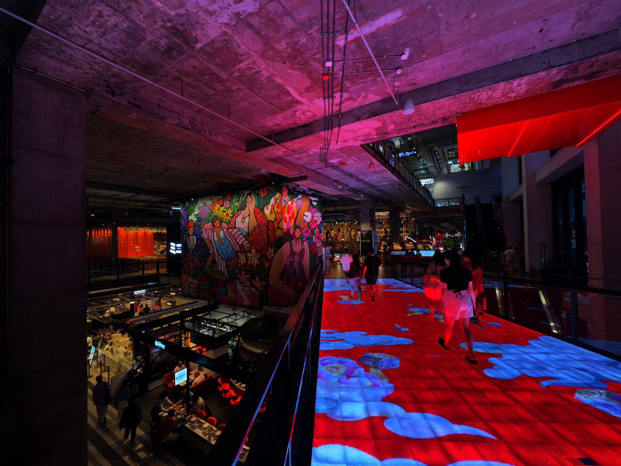 The Commons Thonglor innen – interaktiver LED-Boden in Rot-Blau, farbenfrohe Wandmalerei und Rohbeton-Decke