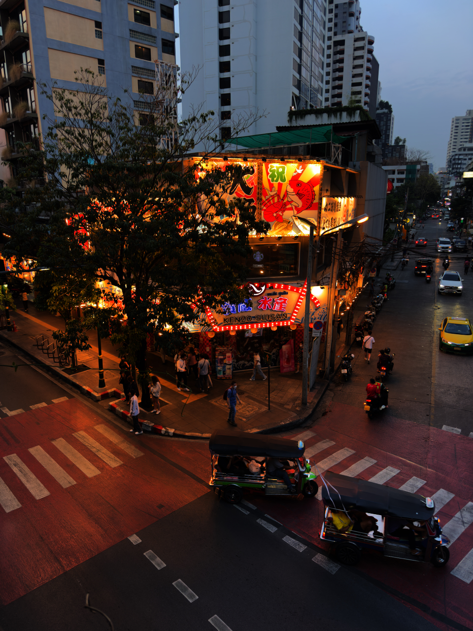 Thonglor Straßenkreuzung von oben bei Nacht – Tuk-Tuks, Neon-Leuchtreklamen, japanische Restaurant-Schilder