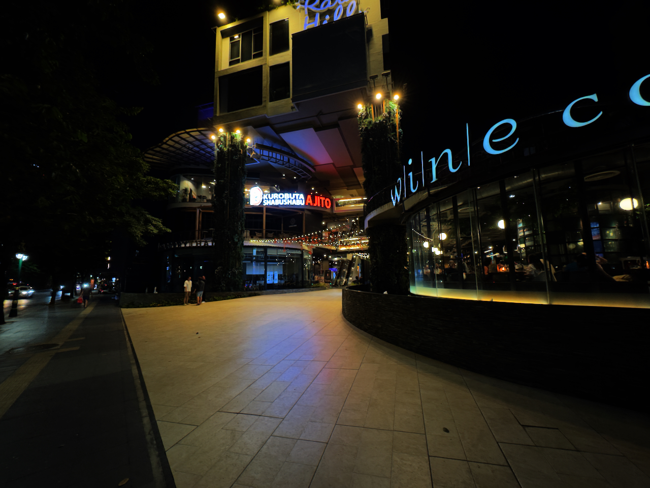 Beleuchtete Restaurant- und Bar-Zeile in Thonglor bei Nacht – eleganter Fußgängerweg mit Ajito und Wine-Bar