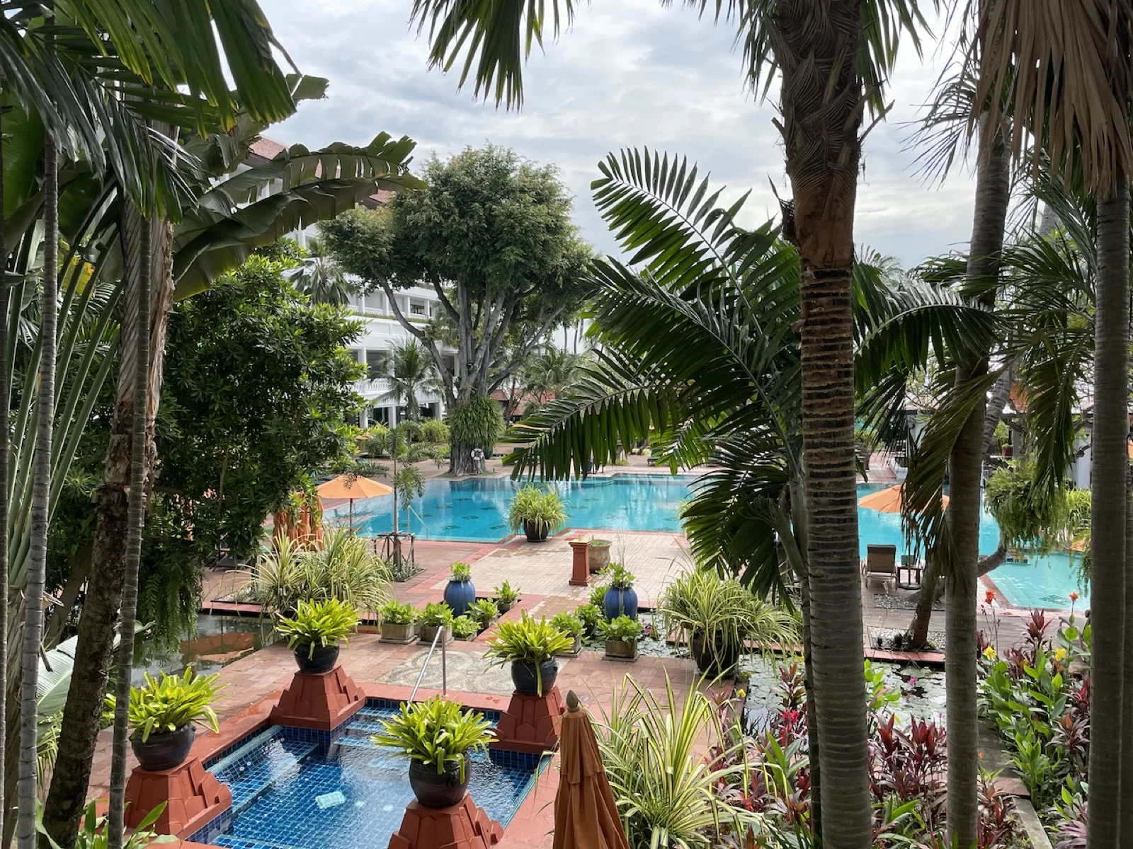 Tropische Poollandschaft mit Palmen im Anantara Riverside Resort in Bangkok