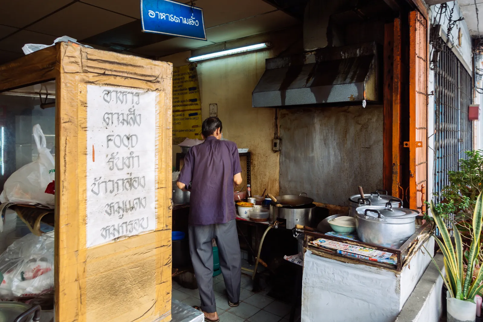 Traditionelle Thai-Garküche mit Koch am Wok in Bangkok