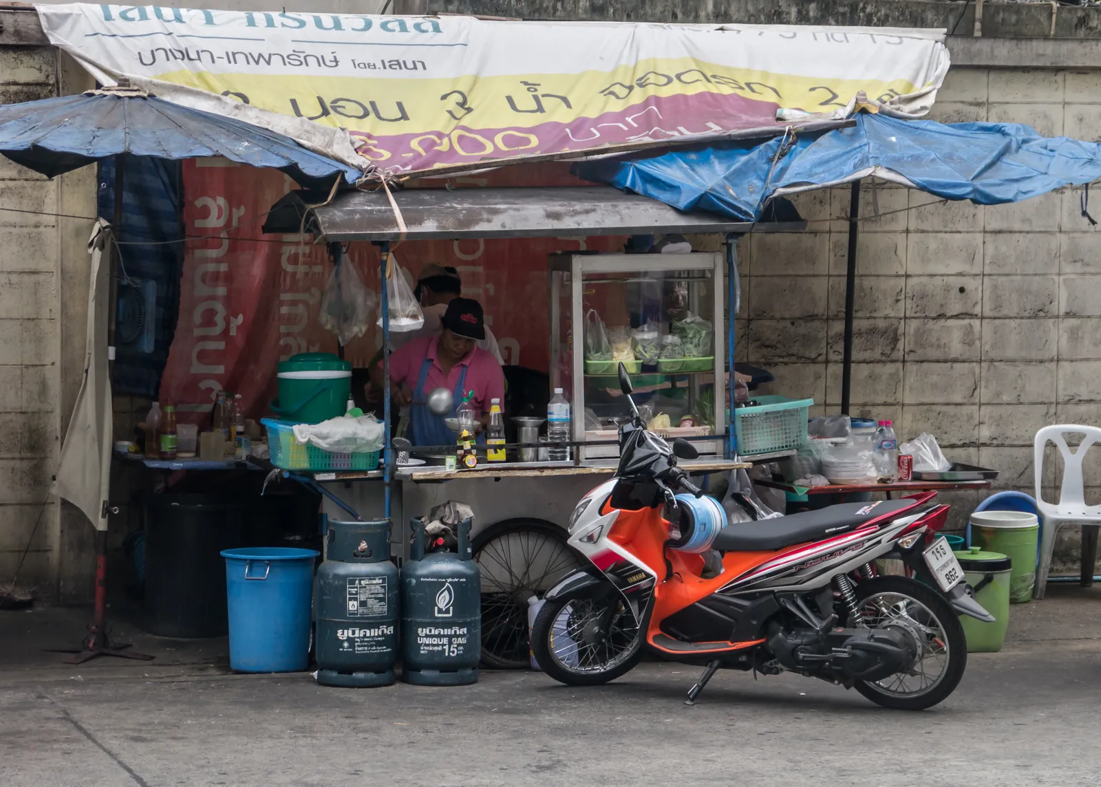 Mobiler Nudelsuppen-Stand mit Köchin und Gasflaschen in Bangkok