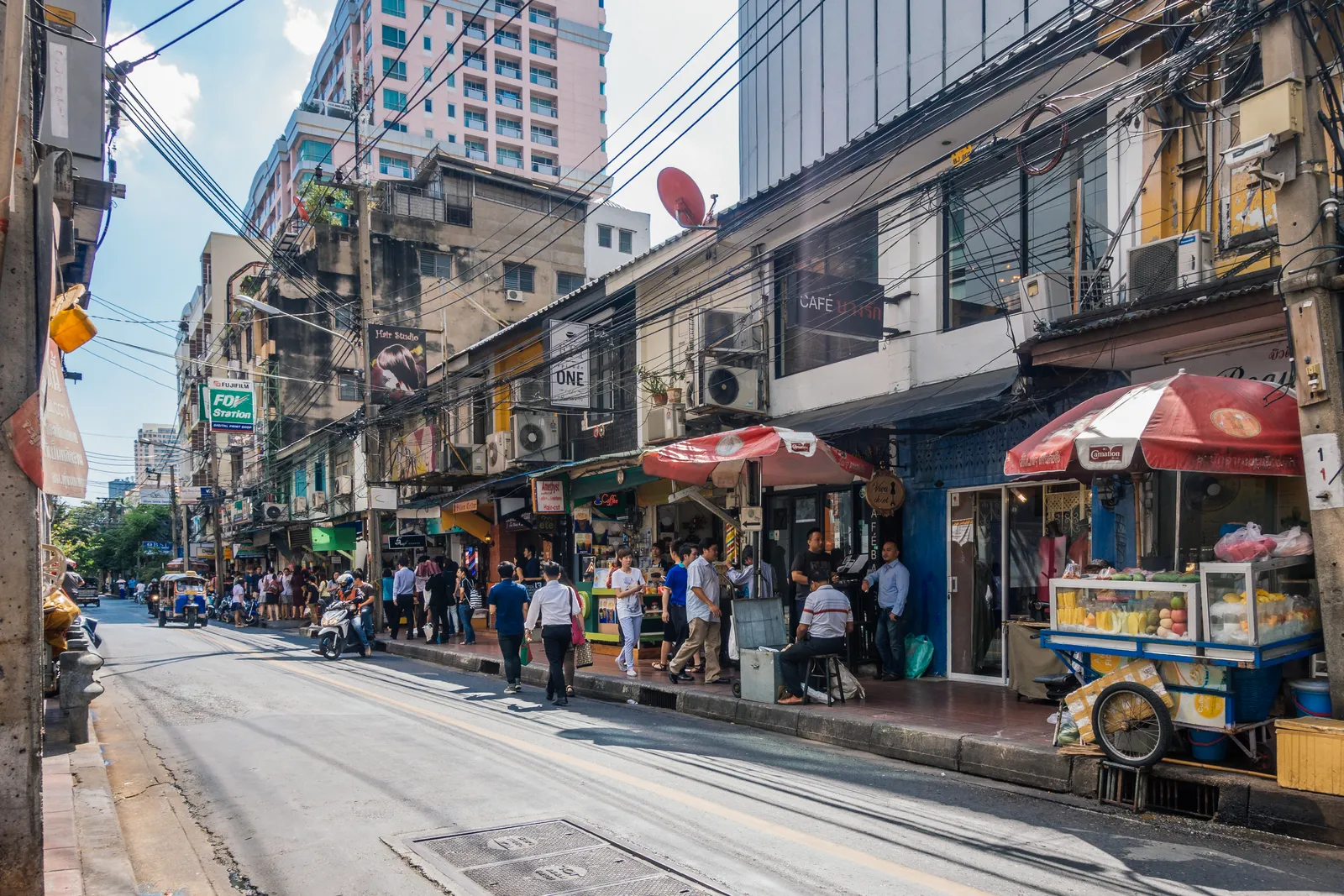 Ruhige Soi mit Cafés, Obststand und Straßenleben in Bangkok