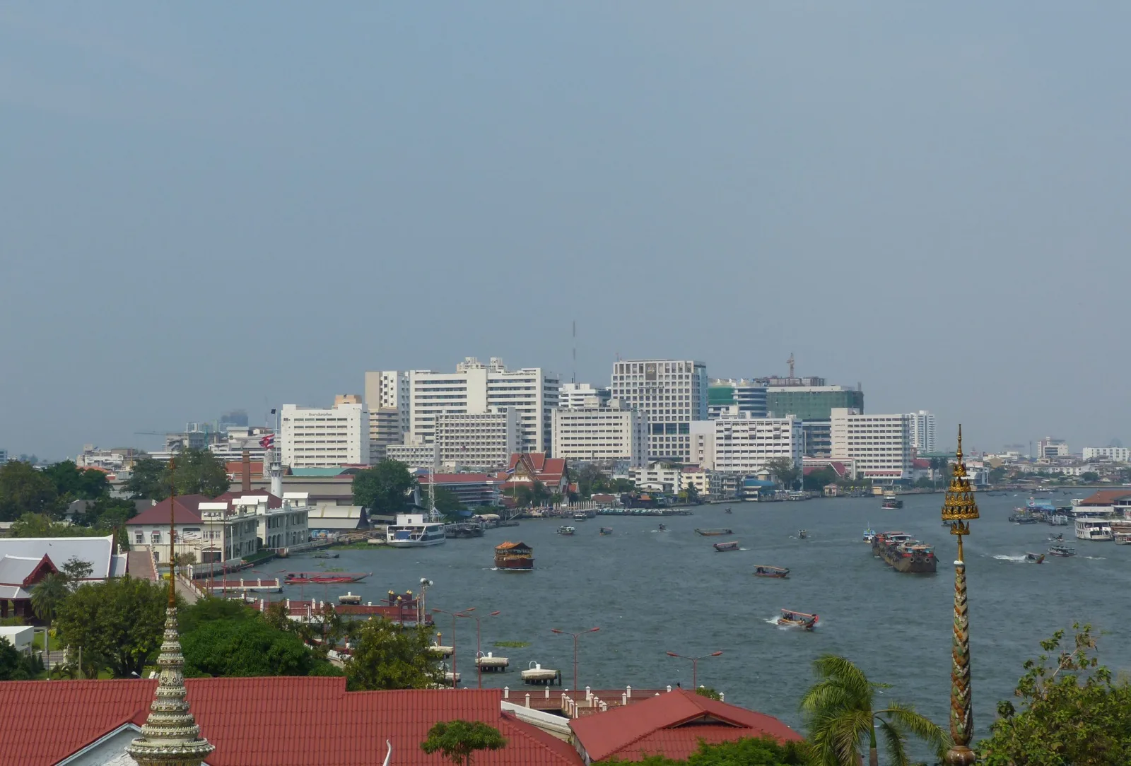 Boote und Fähren auf dem Chao Phraya in Bangkok mit Stadtkulisse
