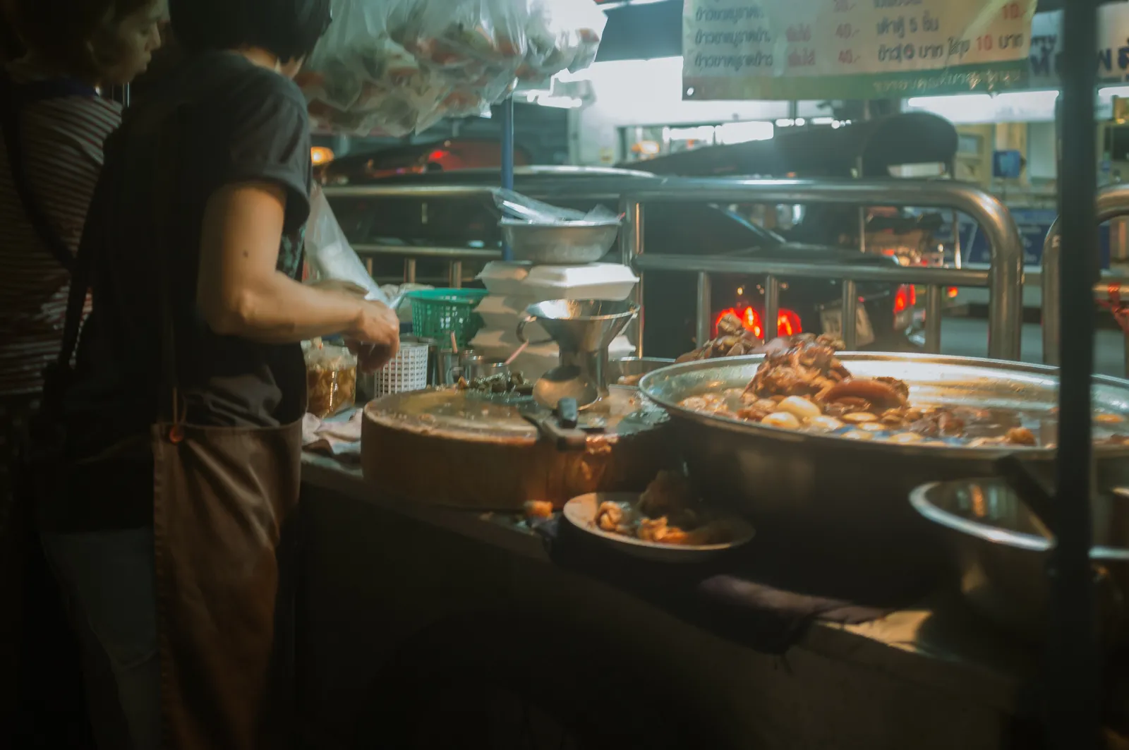 Nächtliche Garküche mit großer Pfanne Khao Kha Mu in Bangkok Chinatown