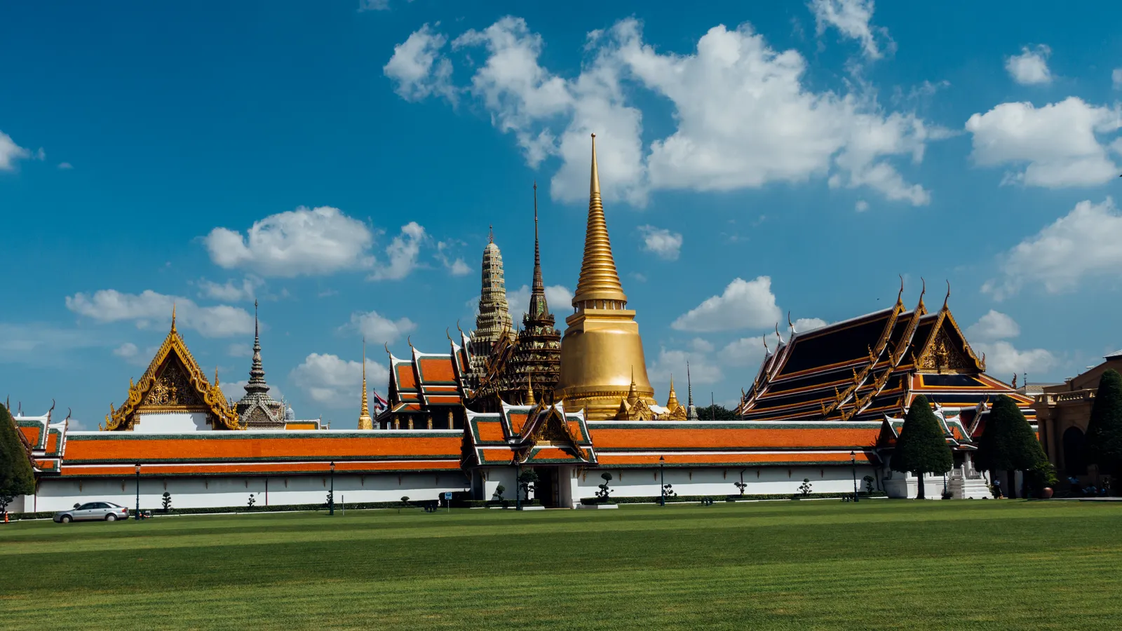 Grand Palace Bangkok mit goldenem Chedi und Wat Phra Kaew vom Sanam Luang aus