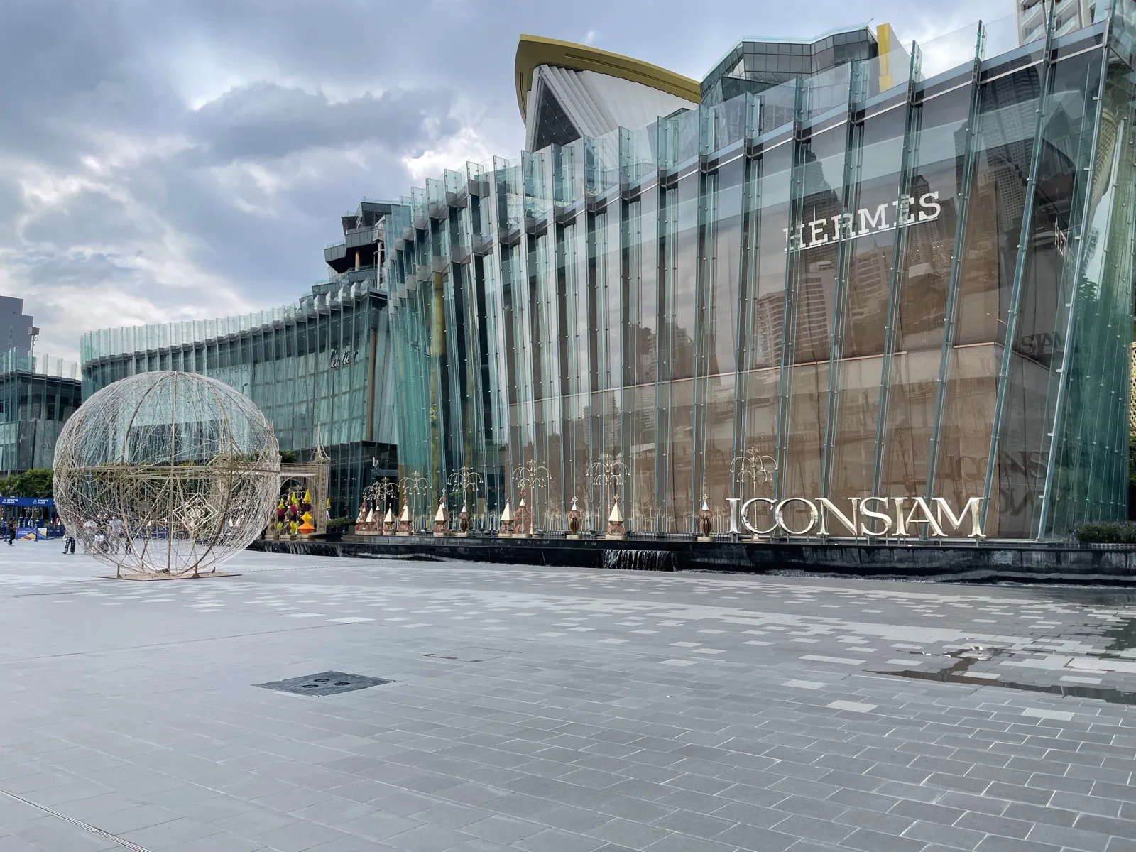 Glasfassade des IconSiam in Bangkok unter dunklen Regenwolken