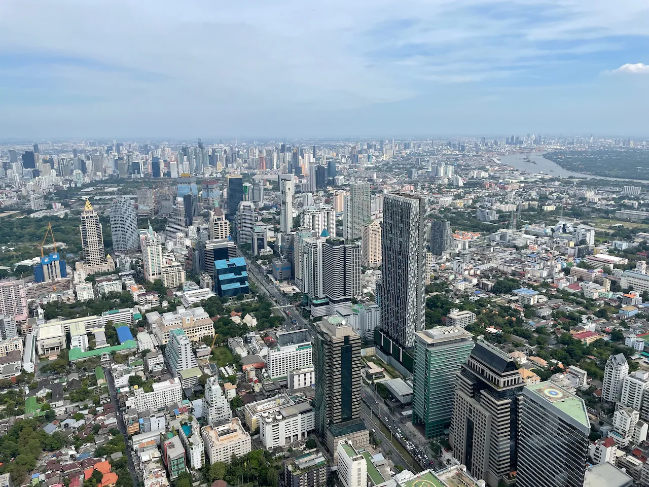 Panoramablick vom Mahanakhon Skywalk über Bangkok mit Lumpini Park und Chao Phraya