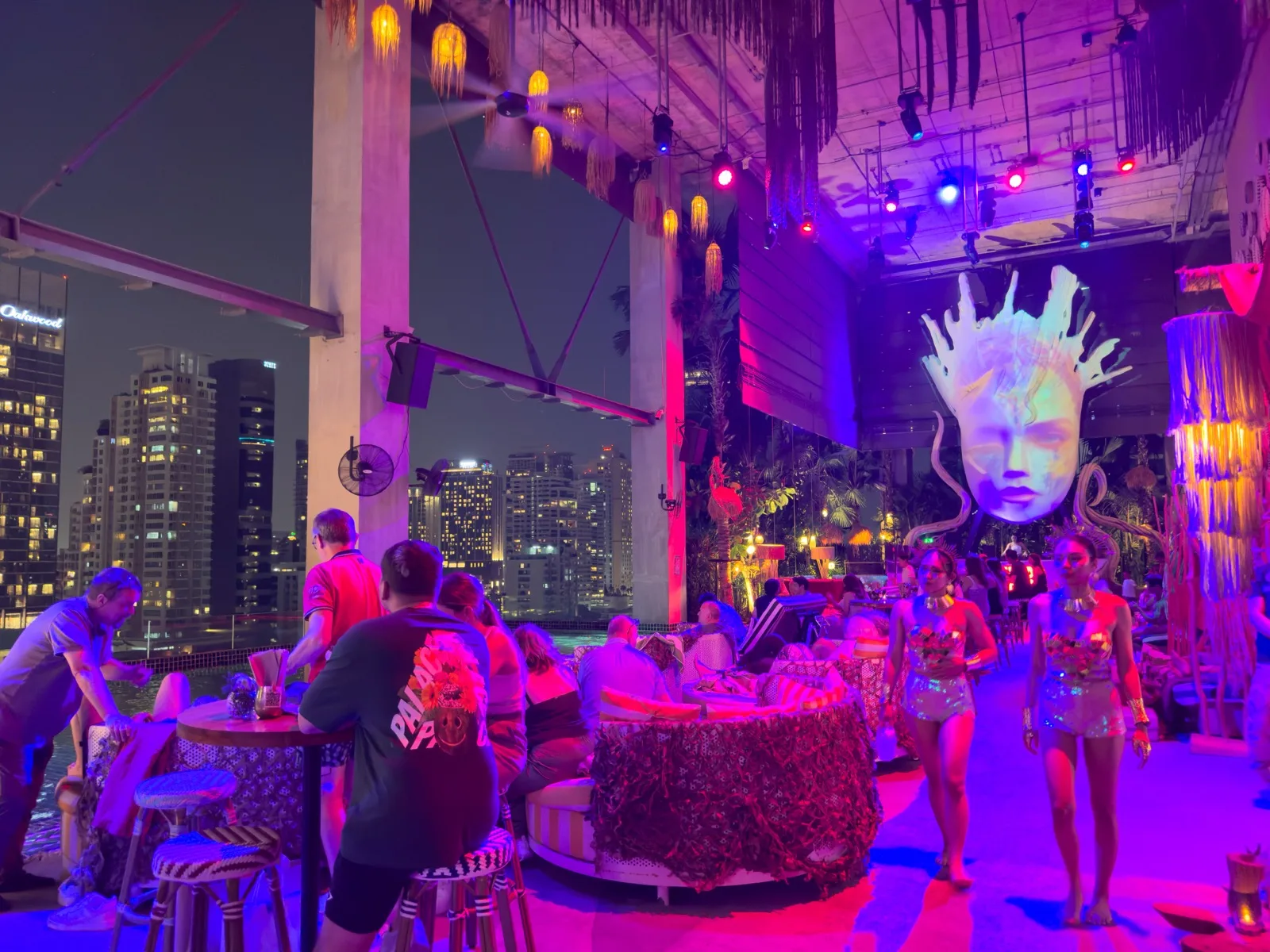 Pool-Party in einem Beach-Club über den Dächern von Bangkok mit bunter Beleuchtung