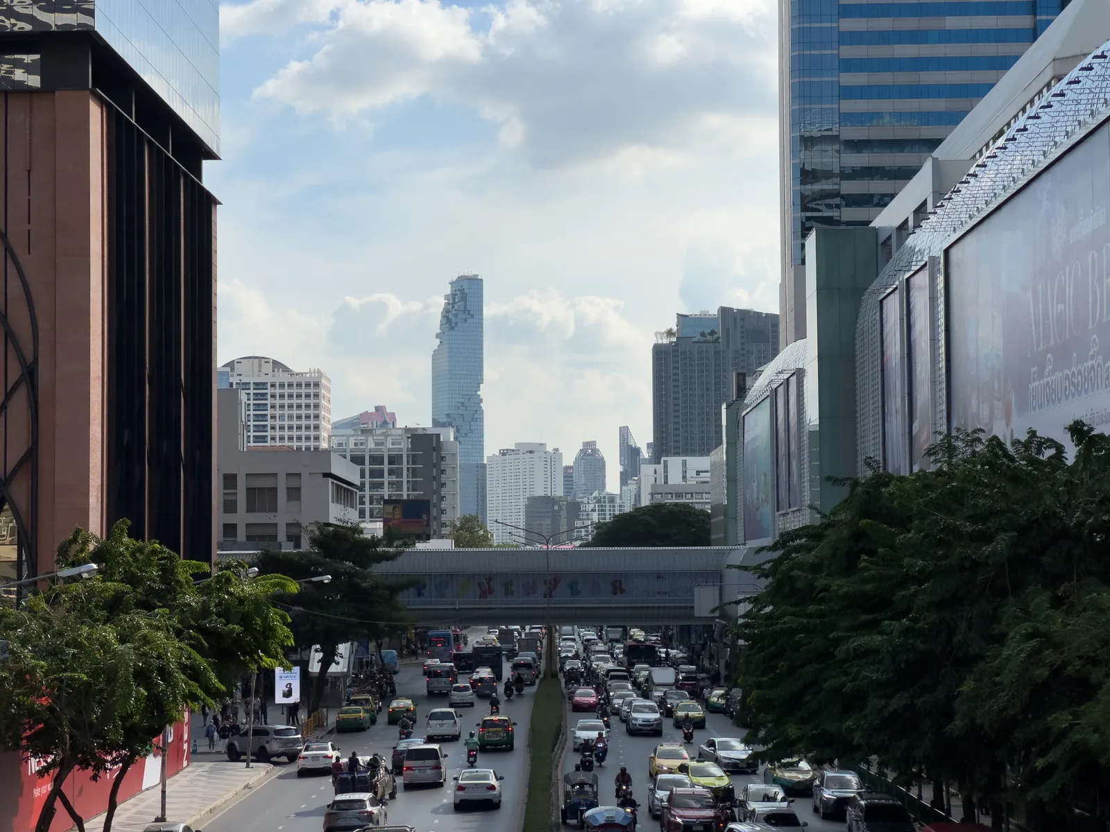 Straßenschlucht in Bangkok mit Blick auf den Mahanakhon Tower in Silom