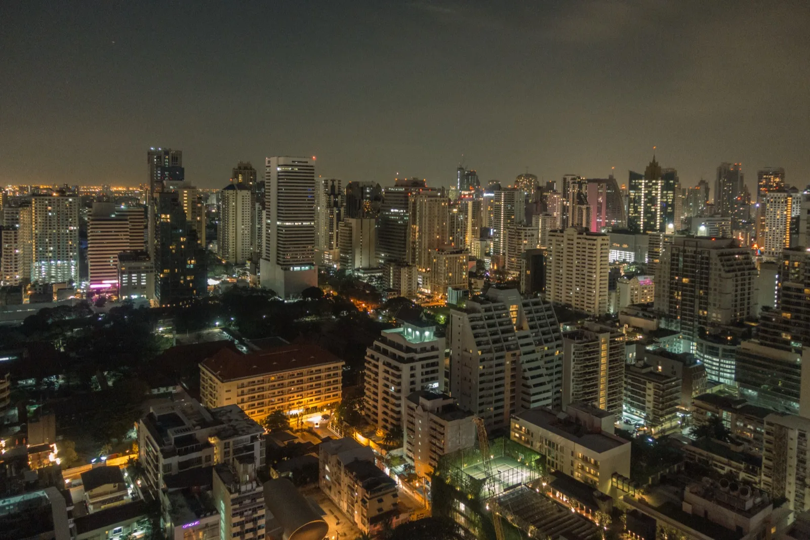 Nächtliche Skyline des Sukhumvit-Viertels in Bangkok mit beleuchteten Hochhäusern