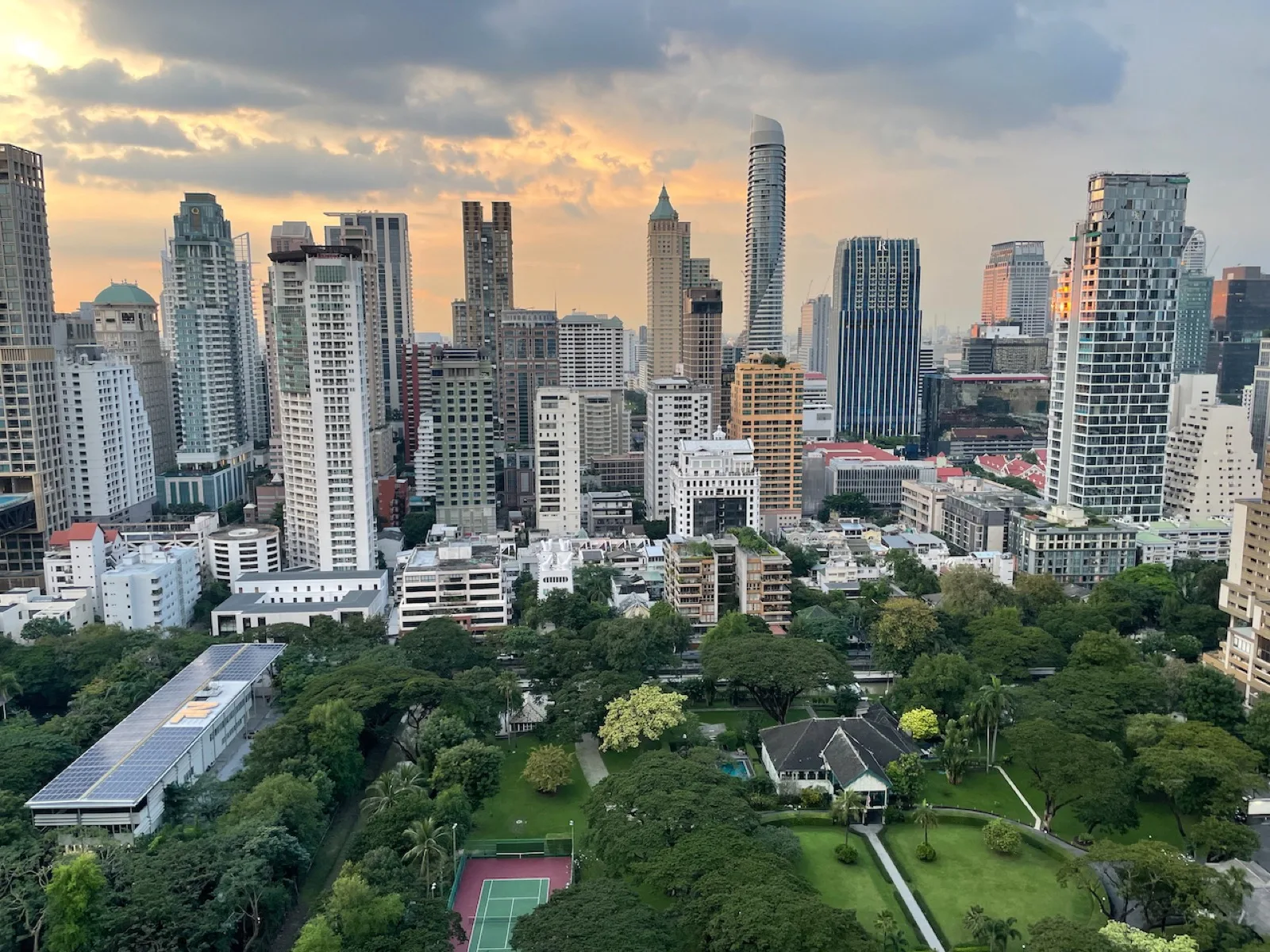 Skyline von Sukhumvit in Bangkok im Abendlicht mit Hochhäusern und grünem Park