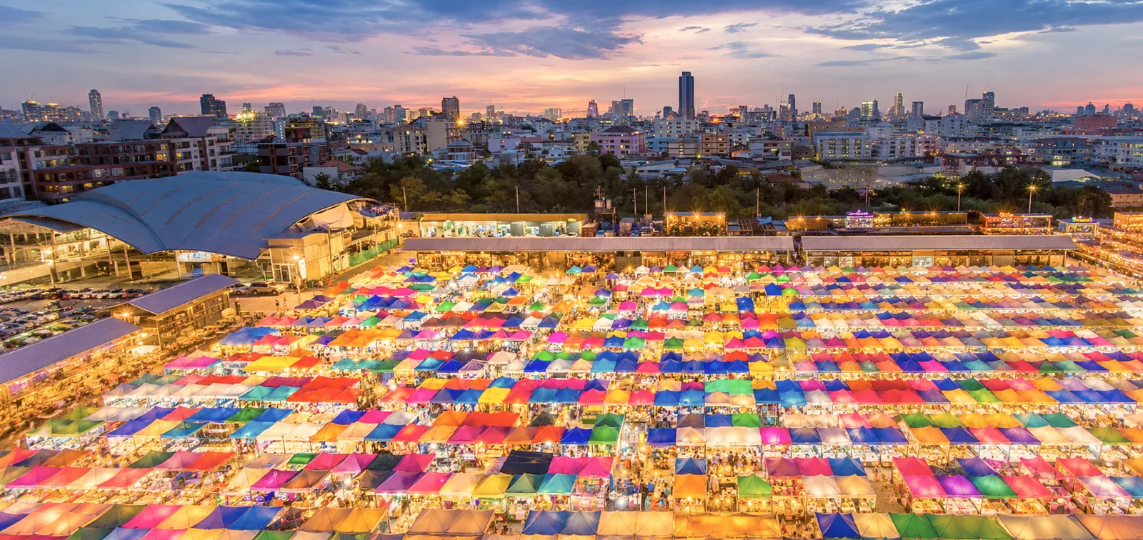 Bunte Zeltdächer des Talad Rot Fai Ratchada Nachtmarkts in Bangkok bei Dämmerung