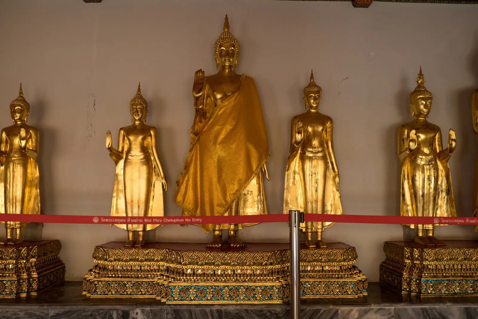 Galerie mit stehenden goldenen Buddha-Statuen im Wat Pho Bangkok