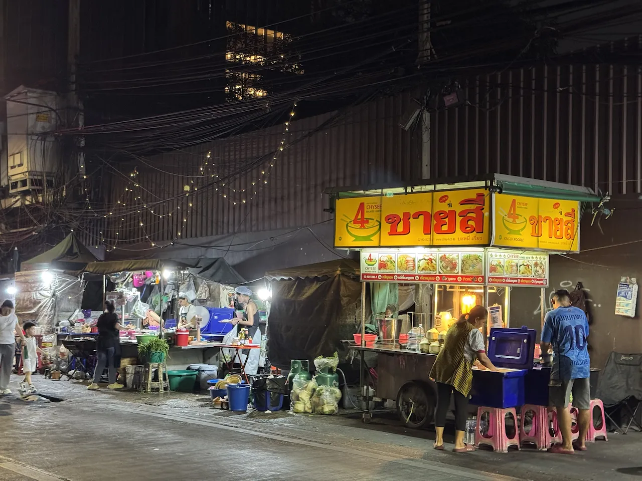 Beleuchtete Streetfood-Stände bei Nacht in Bangkok Chinatown