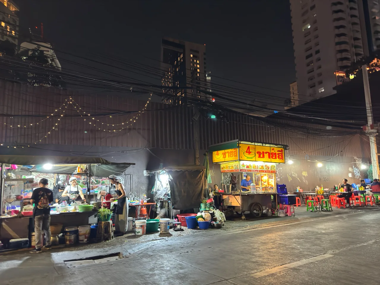 Straßenstände mit Lichterketten am Abend in Bangkok