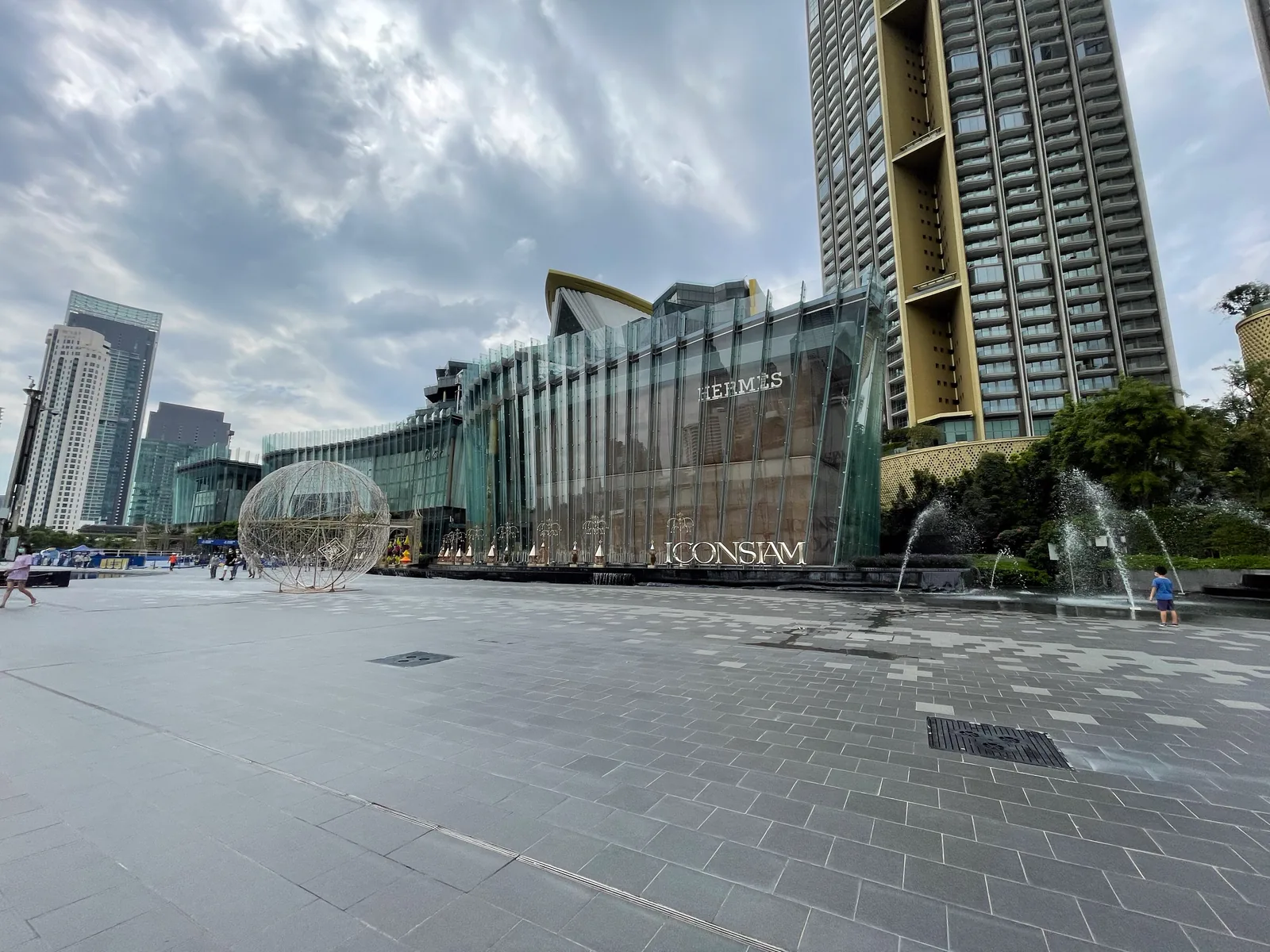 Die geschwungene Glasfassade von ICONSIAM von der Promenade aus gesehen